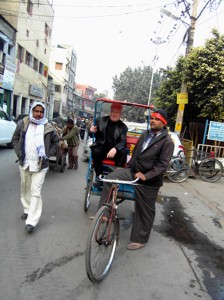 Colour photograph showing a silly tourist on a bicycle rickshaw, as he is brought sightseeing around the Bazaar District in Old Delhi. Click to enlarge. Photograph taken by Mr. Daljeet Singh, Ministry of Tourism, with CJ Walsh's camera. 2010-01-09.