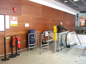 Colour photograph showing a Fire Evacuation Chair Device Installation at Dublin Airport, Ireland. On so many levels and in so many ways, this 'decorative' installation ... intended to demonstrate that an organization is complying with legislation ... will prove to be, in the event of a real fire emergency, SO wrong and unworkable. Photograph taken by CJ Walsh. 2008-04-04. Click to enlarge.